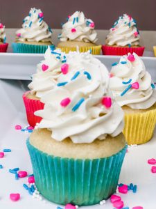 vanilla cupcakes with vanilla frosting and colorful sprinkles